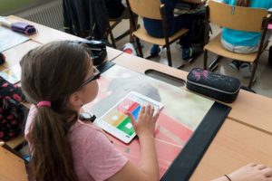 Mädchen lernt mit HIlfe von Tablet in der Schule